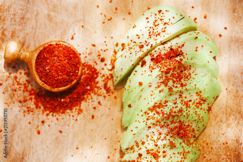 avocado slices sprinkled with aleppo pepper on wood photo