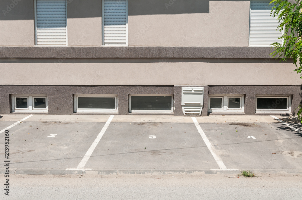 Private parking lot space for cars with reservation numbers in front of the residential building in the city