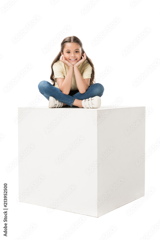 smiling child in casual clothing sitting on white cube isolated on white smiling child in casual clothing sitting on white cube isolated on white