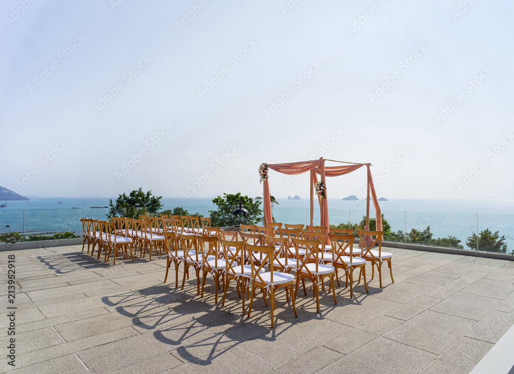 Modern wedding venue setting with wooden folding lawn chairs with sunny sky background