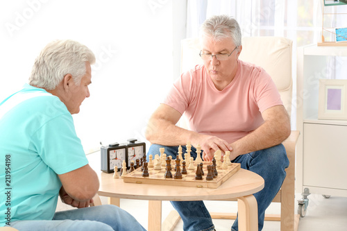Senior men playing chess at care home