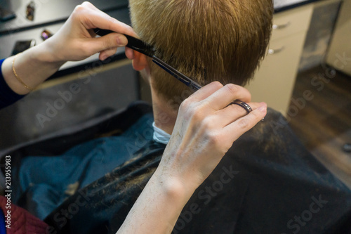 hairdresser cuts a man close up