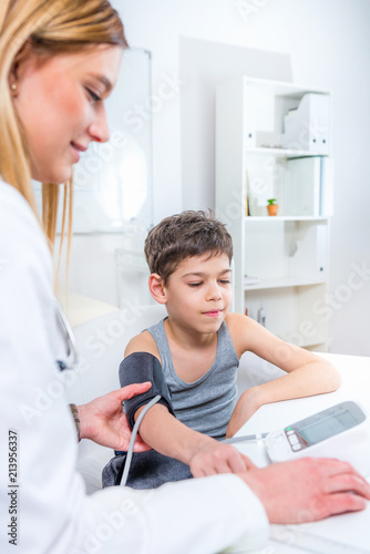 Pediatrician measuring boy’s blood pressure