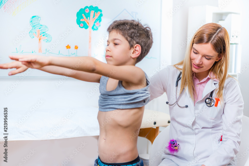 Pediatrician examining boy's spine