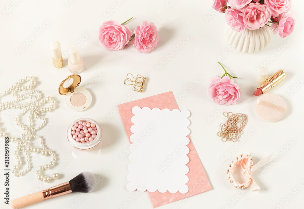 Makeup cosmetic accessories products pearl make up powder and brush, lipstick, perfume, pale pink roses flowers and blank for text on white background. Flat lay. Top view. Copy space Makeup cosmetic accessories products pearl make up powder and brush, lipstick, perfume, pale pink roses flowers and blank for text on white background. Flat lay. Top view. Copy space
