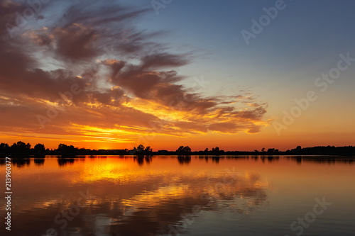 Beautiful cloudy skies reflected in the water during sunset in lake Zoetermeerse plas