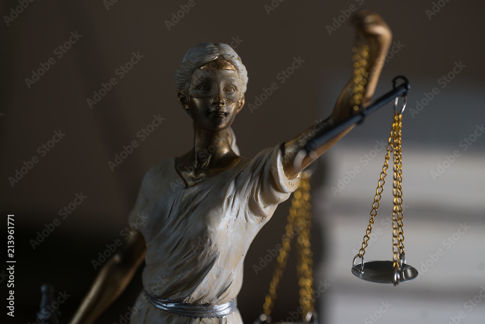 Lawyers office room with the scales of justice, hammer and old law books in the background Lawyers office room with the scales of justice, hammer and old law books in the background