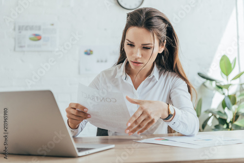 businesswoman working in hot office with documents and laptop