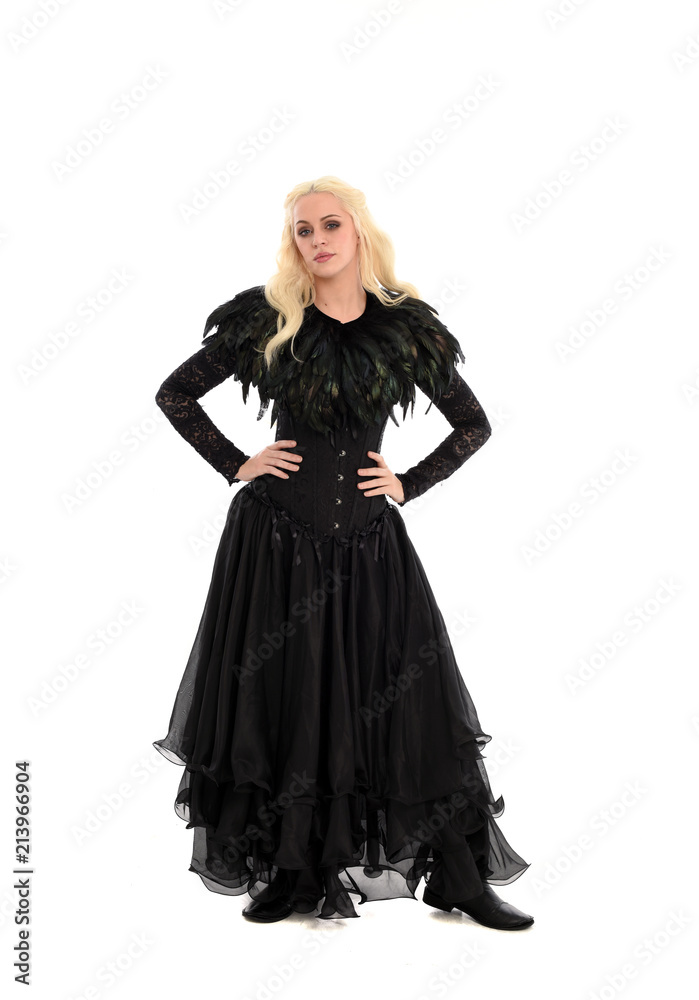 full length portrait of blonde girl wearing corset and long black gown. isolated on white studio background,