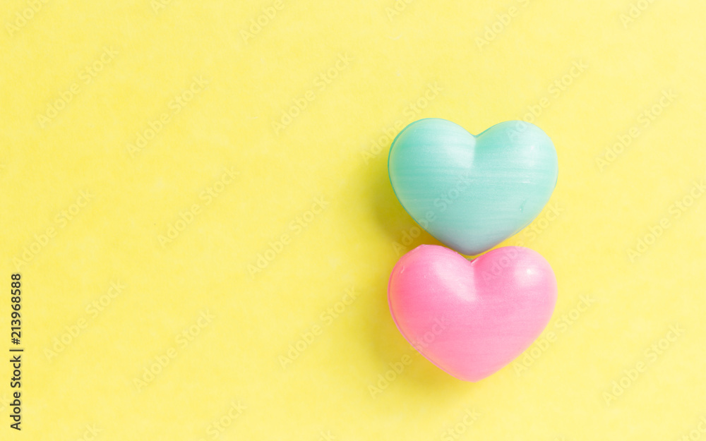 Couple of heart shapes over yellow table. Valentines day symbol for background use. Love, romance, and passion. Couple of heart shapes over yellow table. Valentines day symbol for background use. Love, romance, and passion.