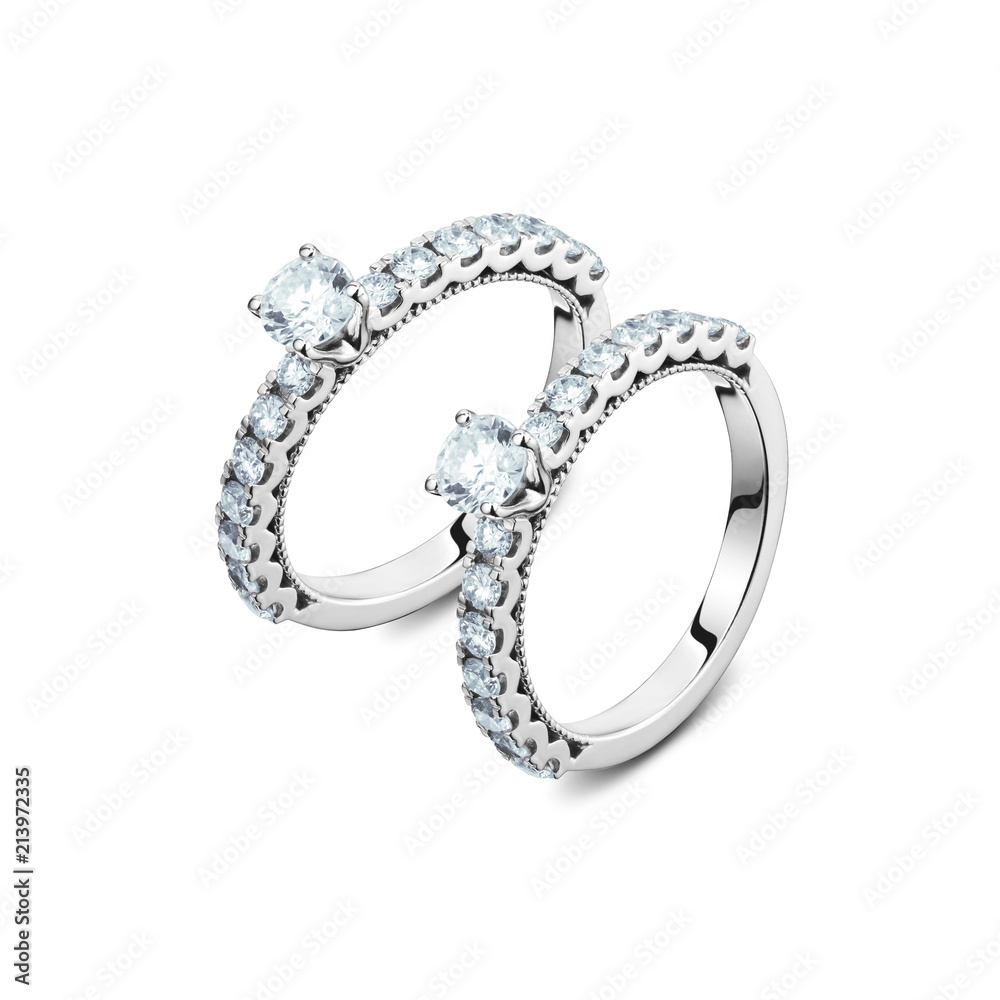 A pair of luxury white gold rings with diamonds on the white background, a pair of golden rings isolated A pair of luxury white gold rings with diamonds on the white background, a pair of golden rings isolated