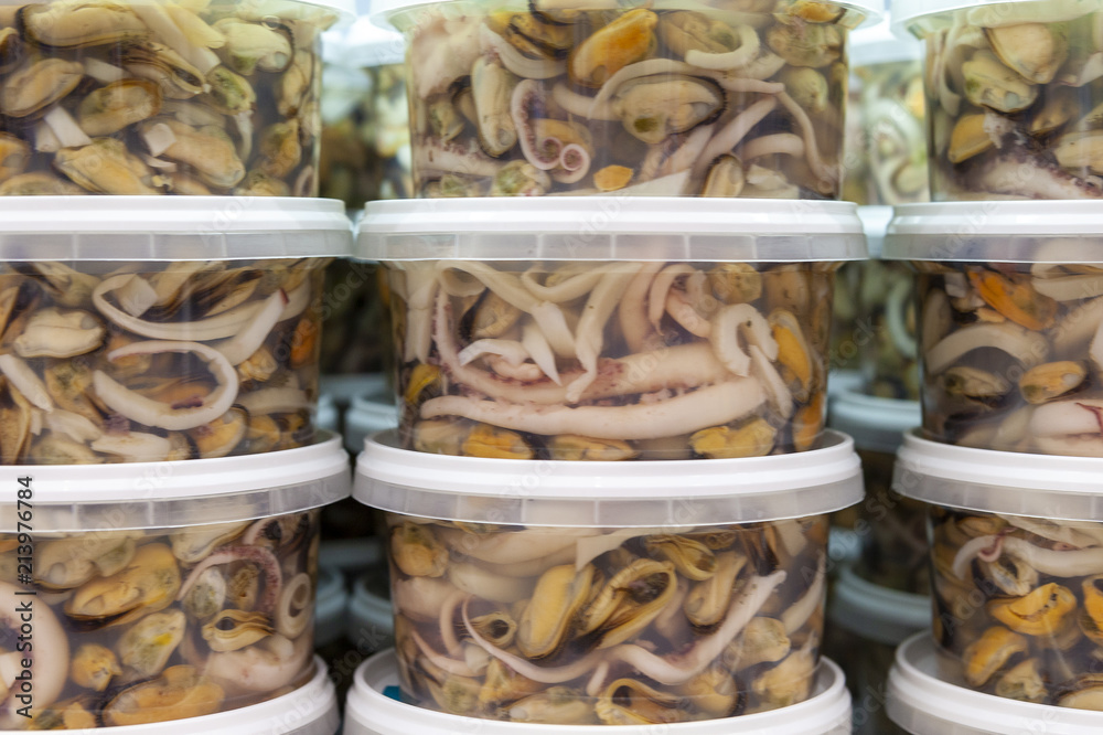 Mussels, squid and octopus in a plastic bank, side view, close up.