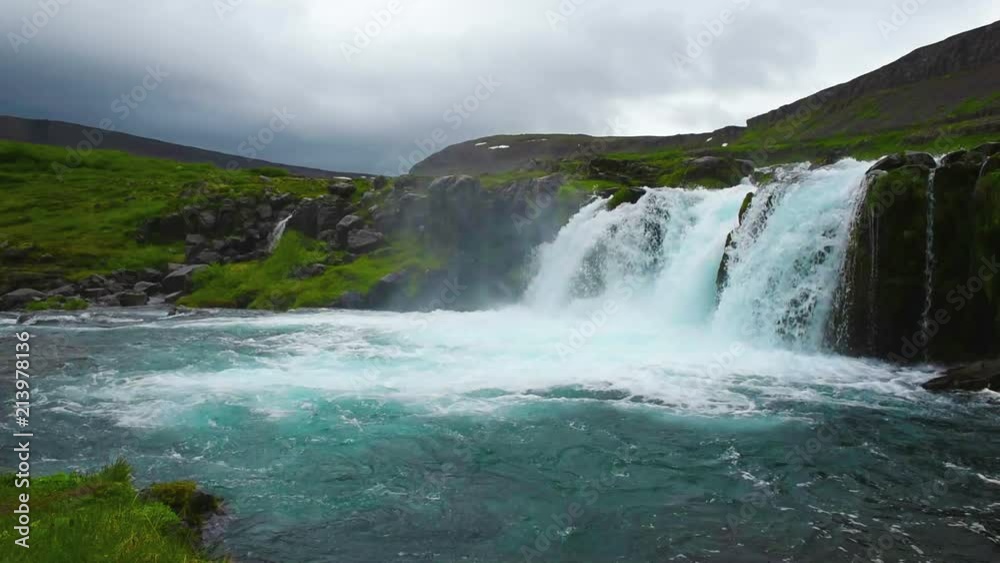 HD video of beautiful, powerful waterfall with lots of water spray and green summer hills in Iceland HD video of beautiful, powerful waterfall with lots of water spray and green summer hills in Iceland