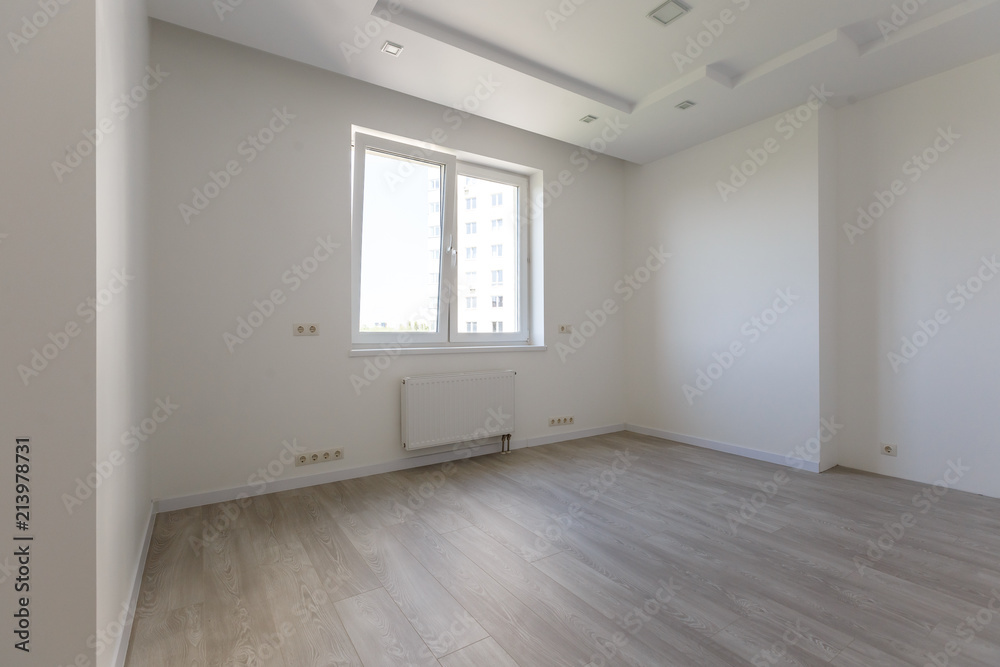 Empty white room with wooden parquet floor after renovation Empty white room with wooden parquet floor after renovation