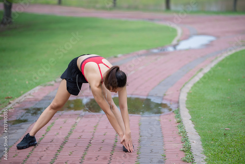 Asian sporty woman stretching body breathing fresh air in the park,Thailand people,Fitness and exercise concept,Jogging in the park