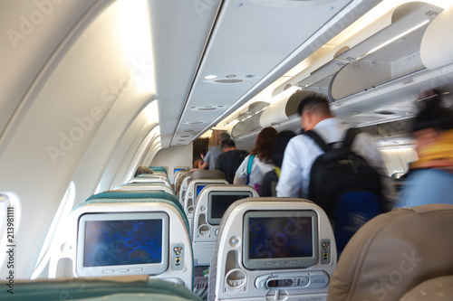 Passengers disembark from the aircraft cabin economy class