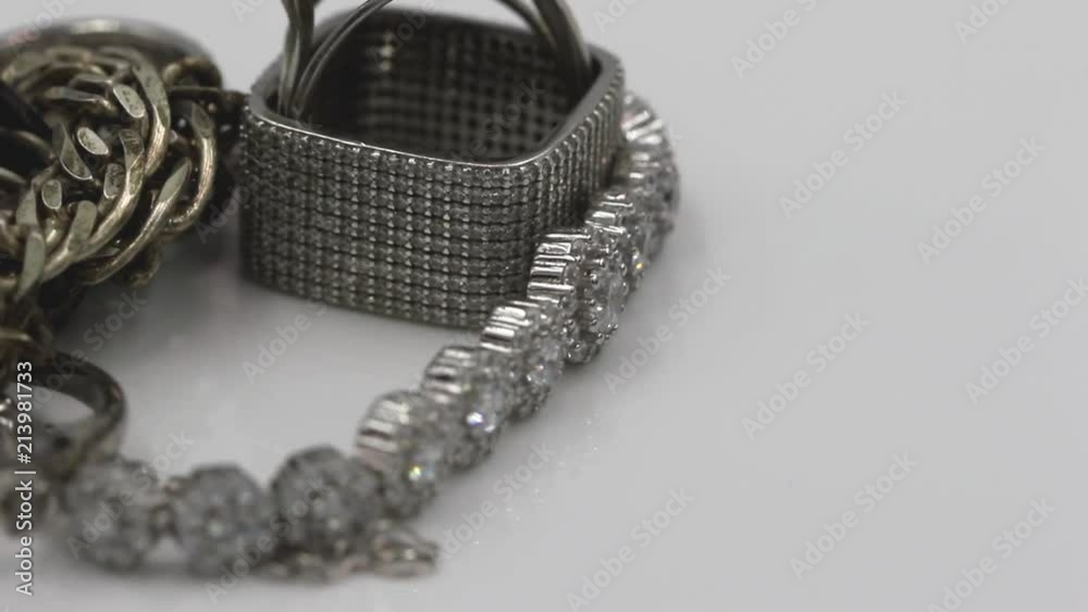 Elegant silver square diamond ring and bracelet with large gemstones rotate on the stand Elegant silver square diamond ring and bracelet with large gemstones rotate on the stand