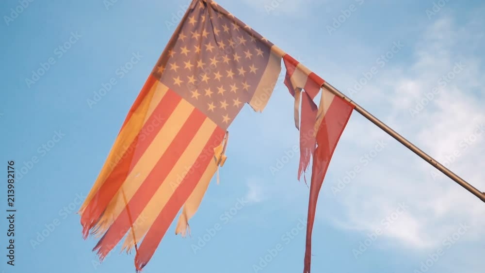 Professional video of United States frayed flag waving in the wind in 4K slow motion 60fps