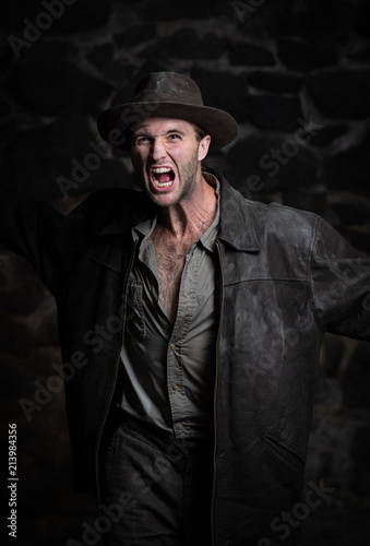 a man in an old hat screams and shows aggression.