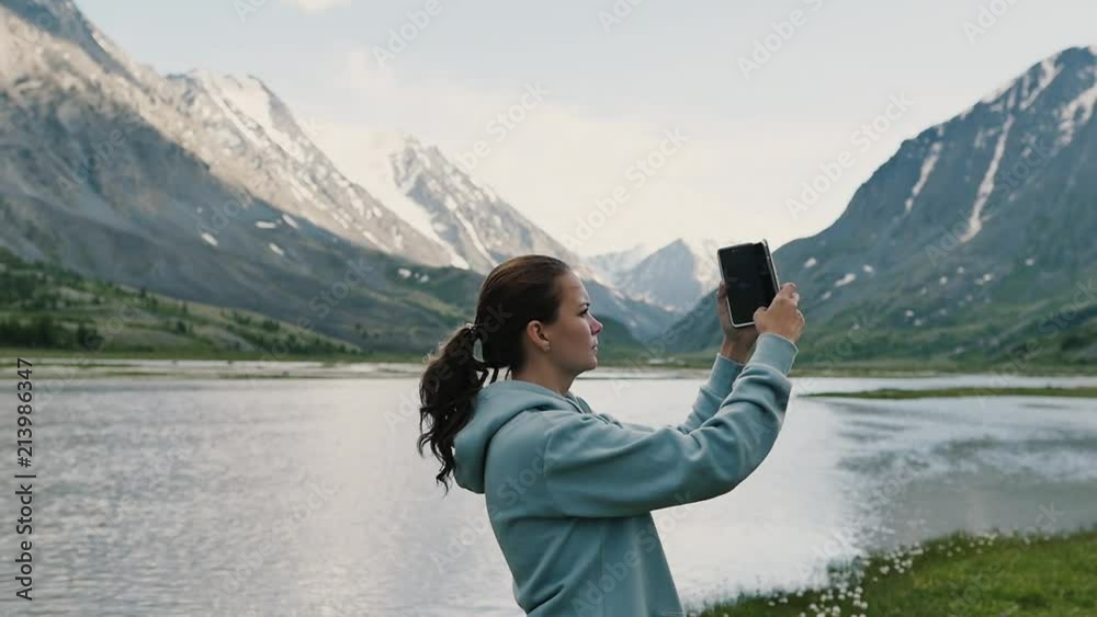 Woman on top of mountain. Girl lifting arm up celebrating scenic nature landscape enjoying vacation travel adventure Woman on top of mountain. Girl lifting arm up celebrating scenic nature landscape enjoying vacation travel adventure