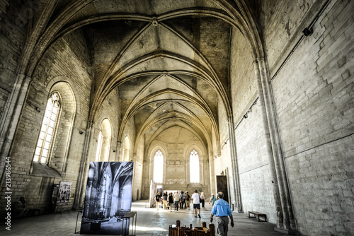 A tour guide leads a group of travelers through the interior of a gothic church in the Palace of the Popes in Avignon France photo