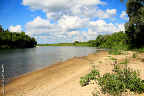 Beautiful scenery, blue sky, white heavy clouds, sandy beach, wide river and lots of greenery
