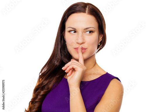 Young beautiful woman has put forefinger to lips as sign of silence