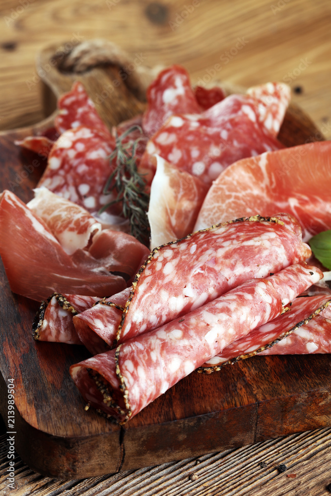 Food tray with delicious salami, raw ham and italian crudo or jamon. Meat platter with selection