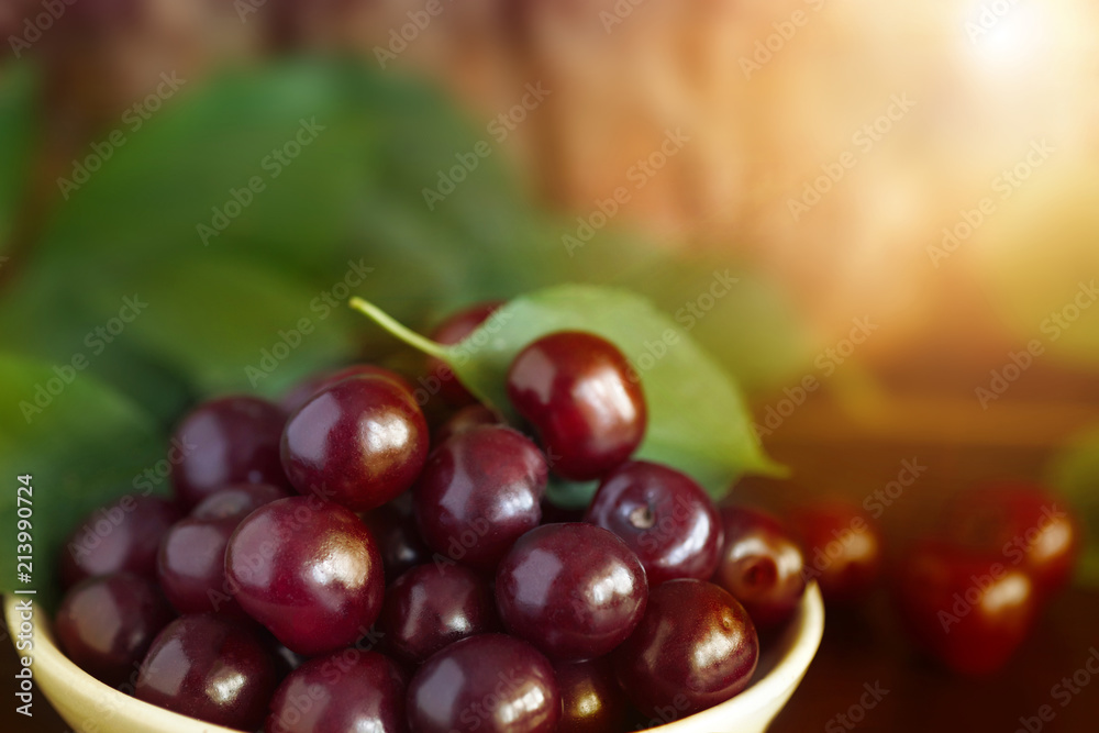 Fototapeta premium Ripe cherry by close-up, on a sunset background, outdoors