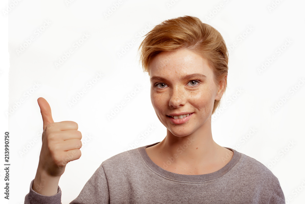 Portrait of a laughing woman showing thumbs up isolated on a white background