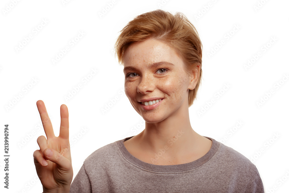 Young and beautiful teenage girl doing victory sign isolated on white Young and beautiful teenage girl doing victory sign isolated on white