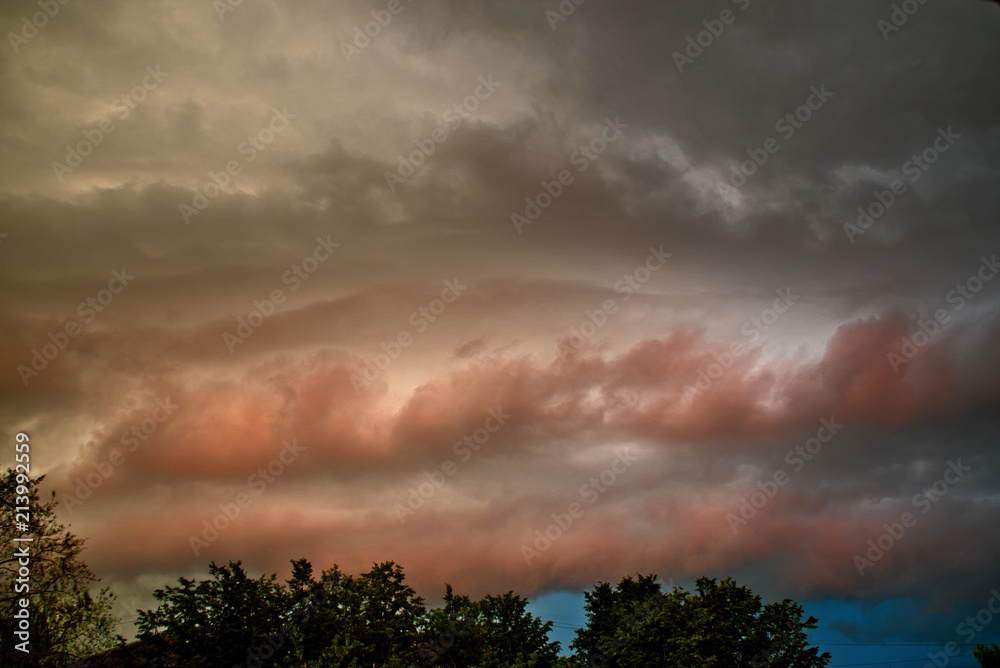 The cloudy sky is illuminated by red light by the setting sun. The cloudy sky is illuminated by red light by the setting sun.
