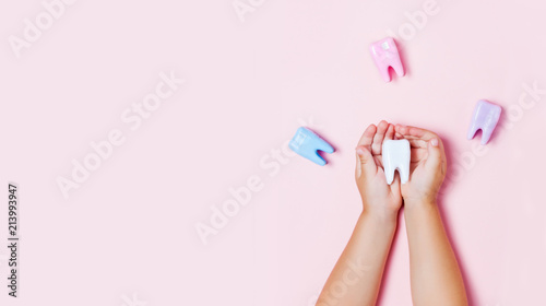 Fototapeta Naklejka Na Ścianę i Meble -  Child's hands holding big tooth and toothbrush