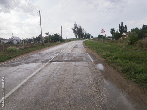 Fototapeta Naklejka Na Ścianę i Meble -  Road in countryside after rain / Winding road in countryside after rain on cloudy day