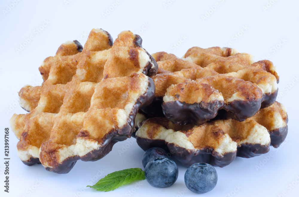 Waffles with chocolate and blueberries on white background. Waffles with chocolate and blueberries on white background.