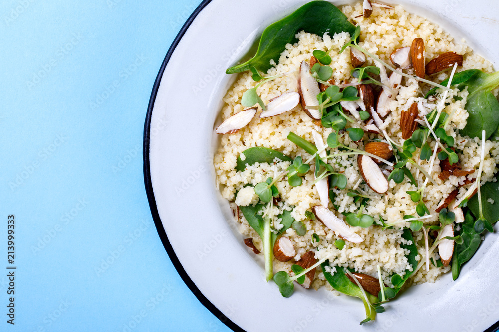 Salad Couscous almond greens Spinach micro greens with Olive Oil on a blue background Top View Copy space for Text Flat Lay Salad Couscous almond greens Spinach micro greens with Olive Oil on a blue background Top View Copy space for Text Flat Lay
