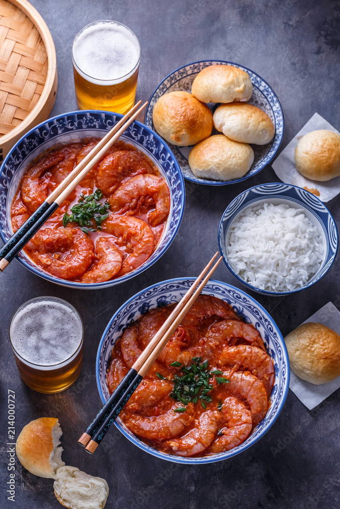 Spicy asian shrimps in tomato sauce with rice, buns and beer, top view Spicy asian shrimps in tomato sauce with rice, buns and beer, top view