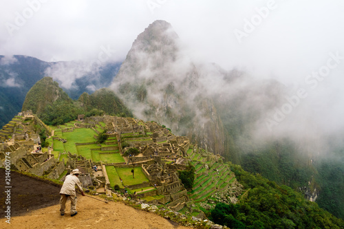 Worker spreads dirt on a terrace of Machu Picchu