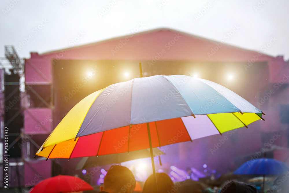 Colorful umbrella in the rain. Outdoor music festival. Rainy weather  Stock-foto | Adobe Stock