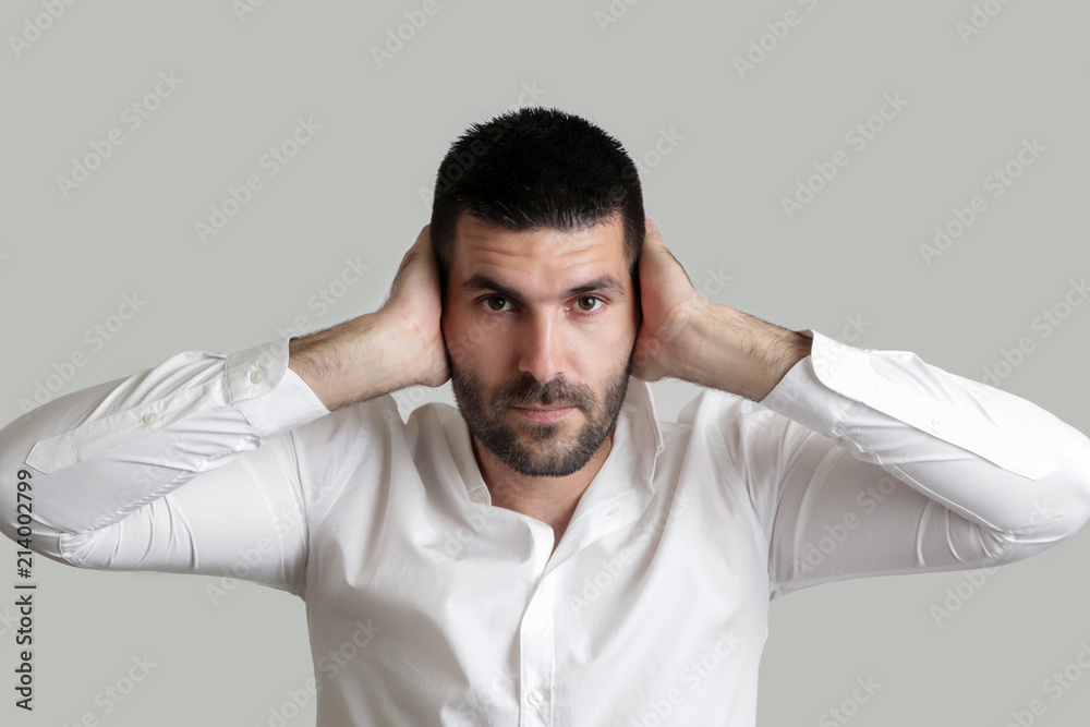 Studio portrait of young businessman covering his ears - hear no evil concept Studio portrait of young businessman covering his ears - hear no evil concept