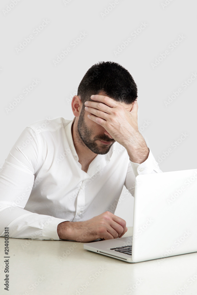 Office life - portrait of young businessman struggling with a project Office life - portrait of young businessman struggling with a project