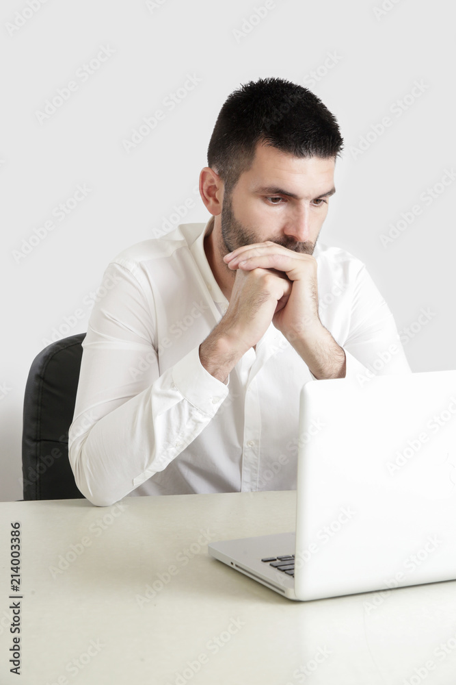 Studio portrait of young businessman in front of his laptop
Studio portrait of young businessman in front of his laptop