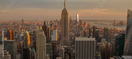 View of Manhattan skyline at sunset or golden hour. Buildings are bathed in golden light. © Patrick