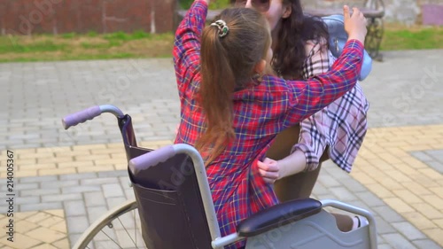 a disabled woman in a wheelchair mother hugs daughter steady shot