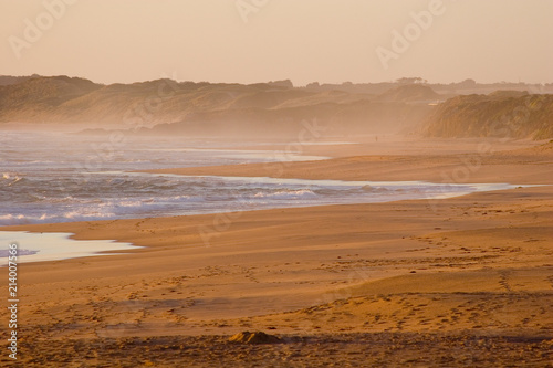 Surf beach with seaspray at sunset