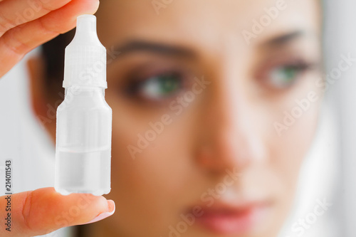 Vision And Medicine Concept. Young Girl Holds Eye Drops In Hands. Portrait of a Beautiful Woman with Contact Lenses. Healthy Look. High Resolution