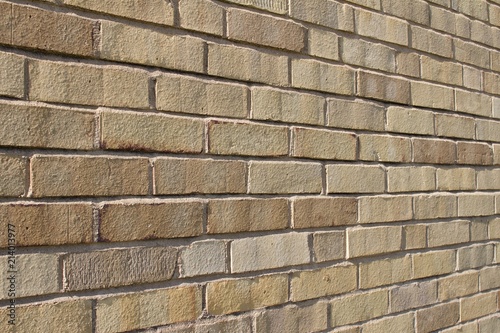 Angle view of an attractive light brown brick wall background with a Flemish stretcher bond pattern