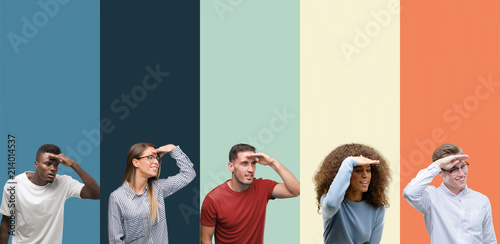 Group of people over vintage colors background very happy and smiling looking far away with hand over head. Searching concept.