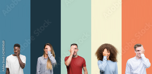 Group of people over vintage colors background covering one eye with hand with confident smile on face and surprise emotion.