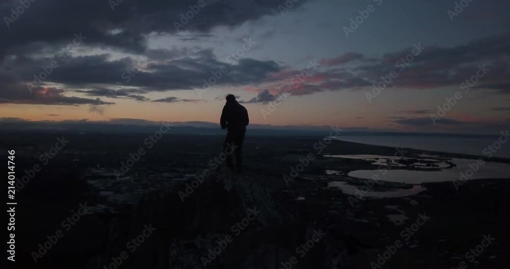 Man silhouetted at sunset with city background. Man silhouetted at sunset with city background.